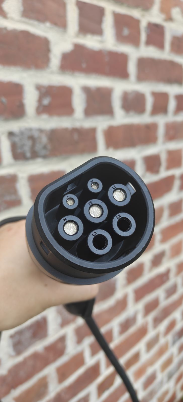 Gros plan sur un connecteur de recharge Type 2, prévu pour le triphasé mais câblé ici en monophasé