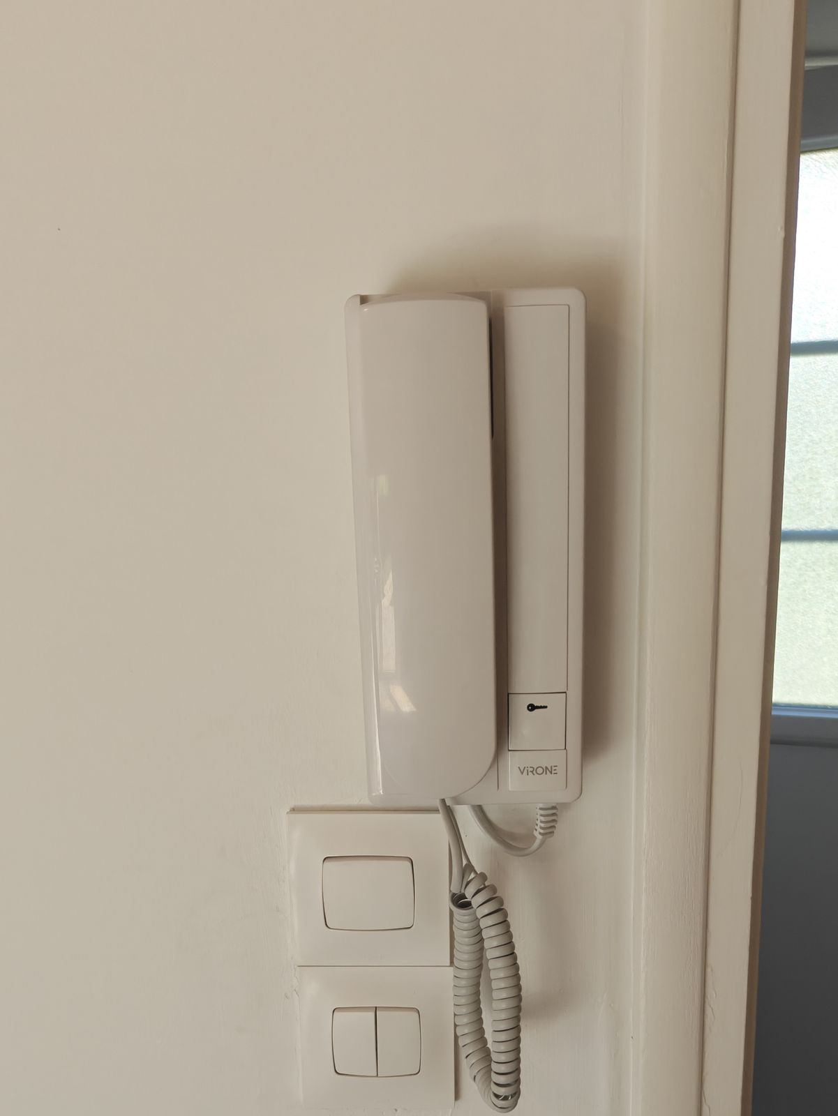 Combiné intérieur d'un interphone audio fixé au mur près de l'entrée